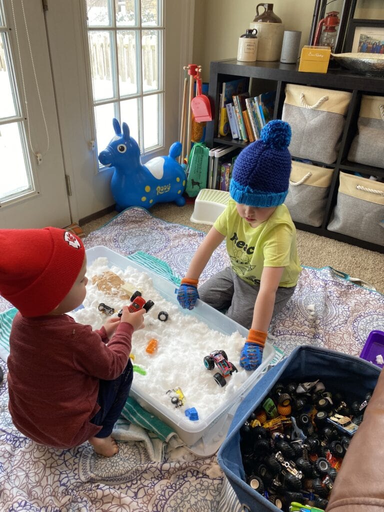 Children sensory play with snow bin inside